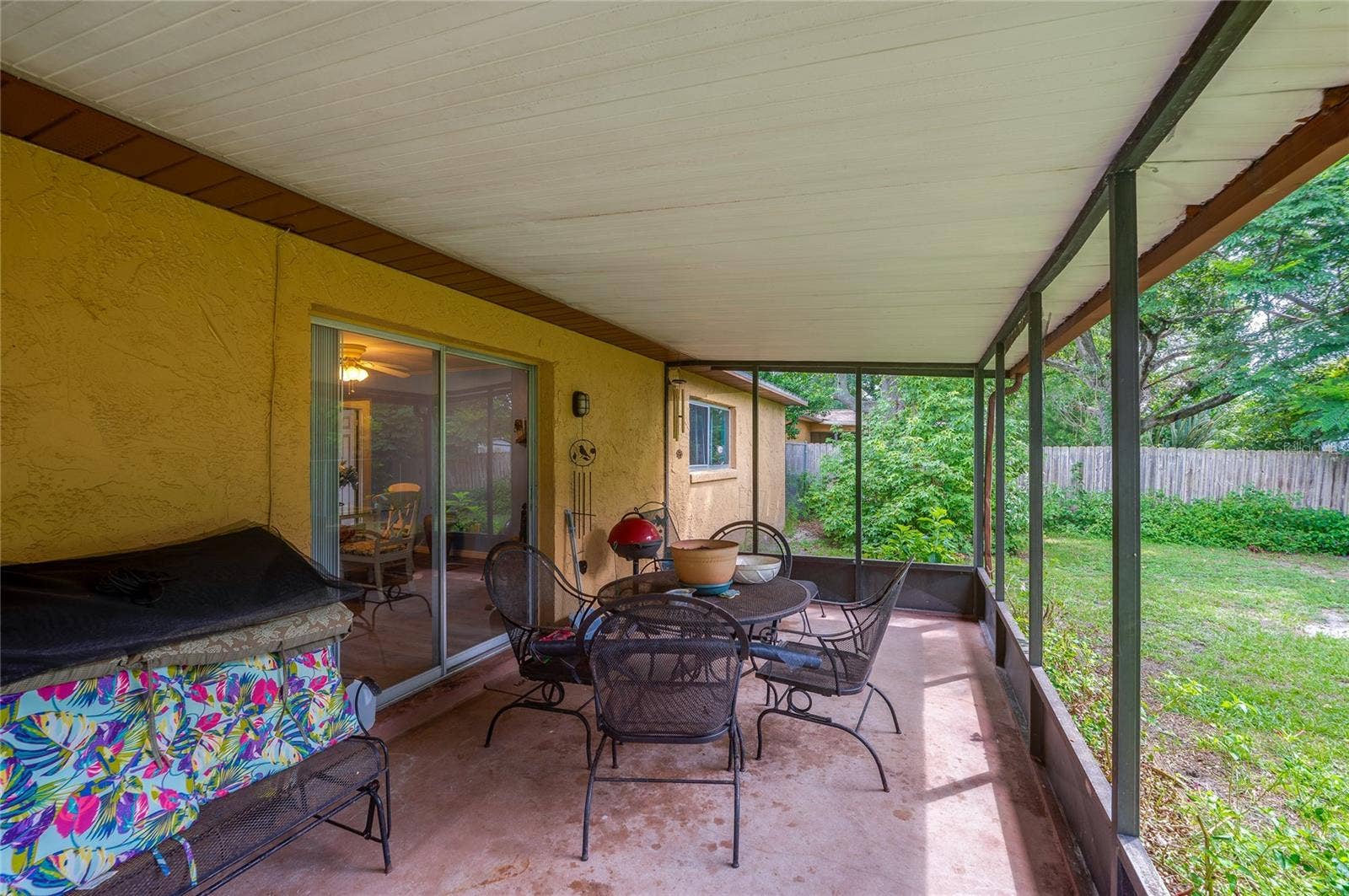 146 WESTWOOD DRIVE, Daytona Beach, FL 32119 Covered, screened outdoor patio space with concrete flooring and sliding door access to the main interior.