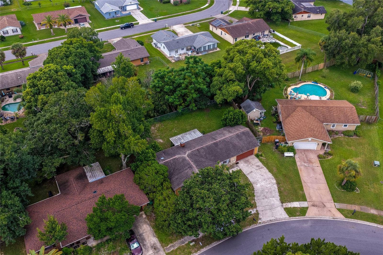 146 WESTWOOD DRIVE, Daytona Beach, FL 32119 Close aerial view highlighting the home, surrounding tree canopy, driveway layout, and adjacent properties.