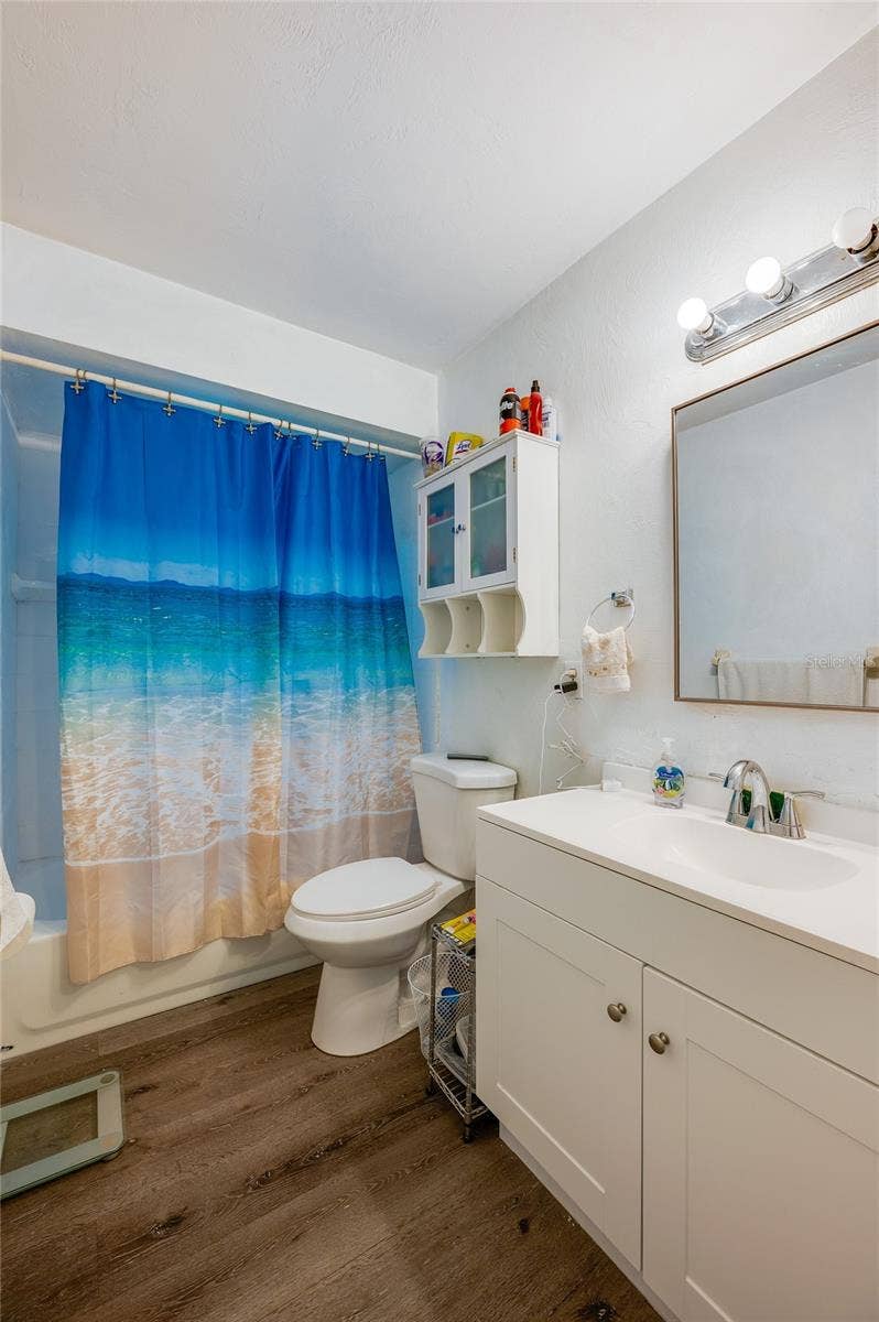 146 WESTWOOD DRIVE, Daytona Beach, FL 32119 Full bathroom with a white vanity, mirrored medicine cabinet, and LVP flooring.