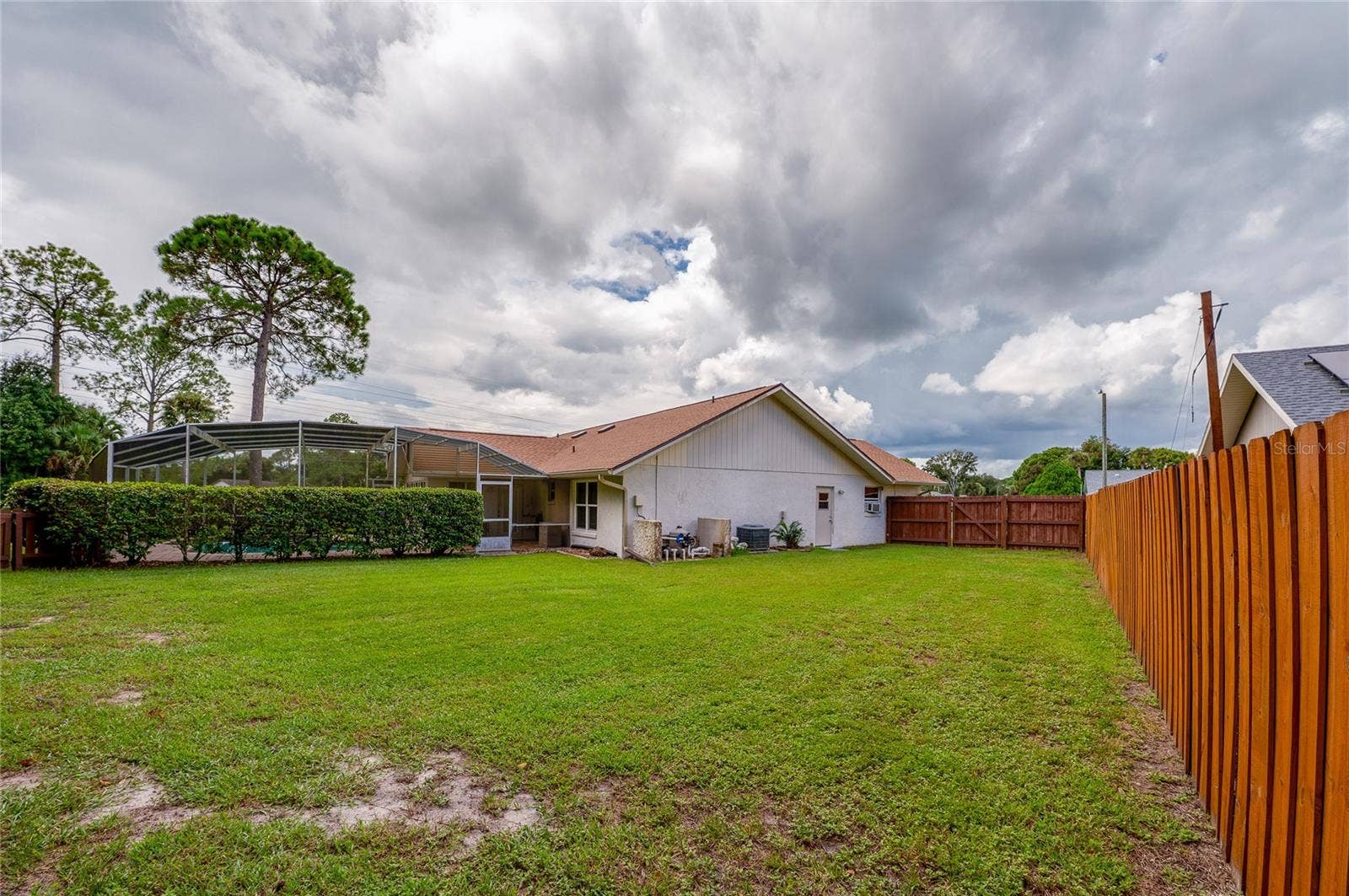 4669 SECRET RIVER TRAIL, Port Orange, FL 32129 Full view of the rear elevation and spacious yard surrounded by a wooden privacy fence.