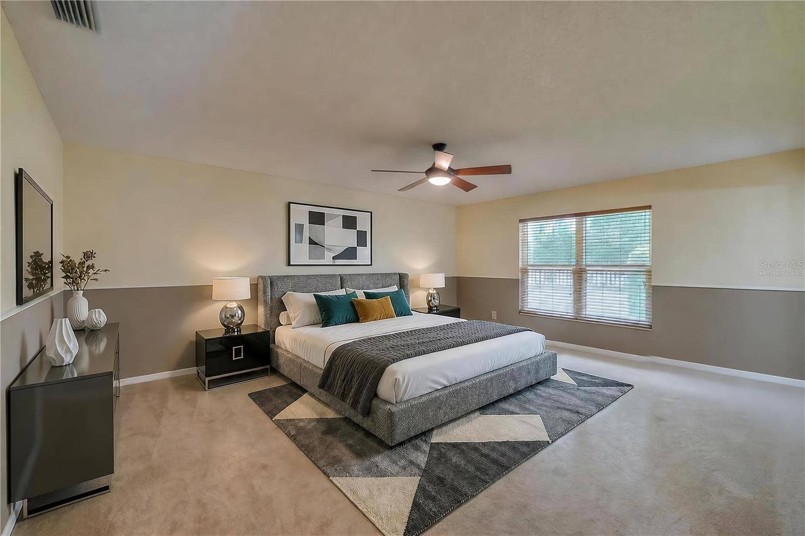 4669 SECRET RIVER TRAIL, Port Orange, FL 32129 Virtually Staged - Spacious primary bedroom featuring soft carpeting, two-tone painted walls, a central ceiling fan, and a large window providing pleasant outdoor views.