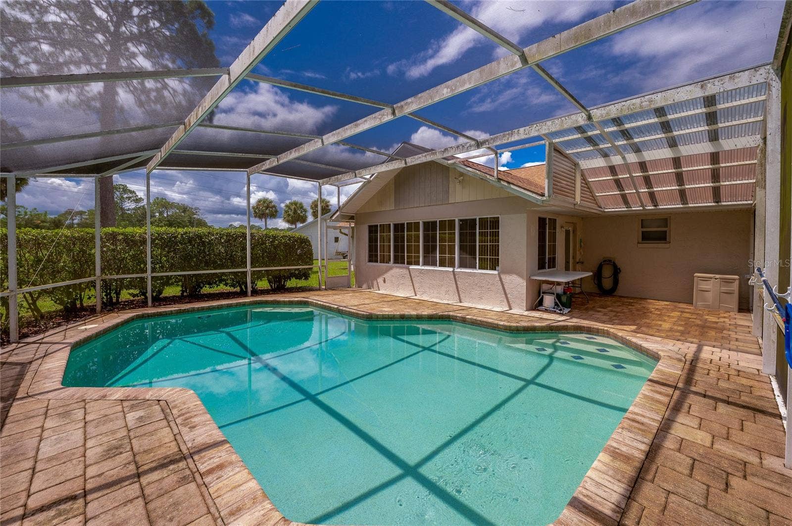 4669 SECRET RIVER TRAIL, Port Orange, FL 32129 Spacious screened lanai showcasing an in-ground swimming pool, brick pavers, and direct access to the home.