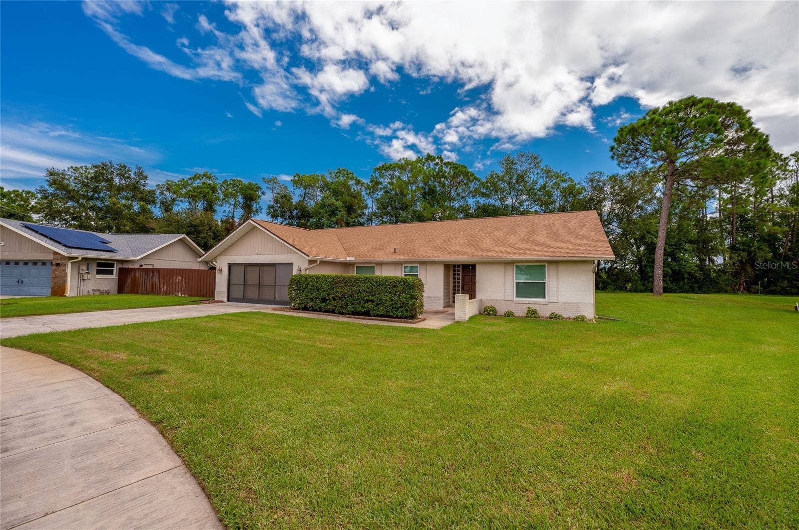 4669 SECRET RIVER TRAIL, Port Orange, FL 32129 Charming single-story exterior showcasing a wide paved driveway, manicured green lawn, and low-maintenance landscaping.