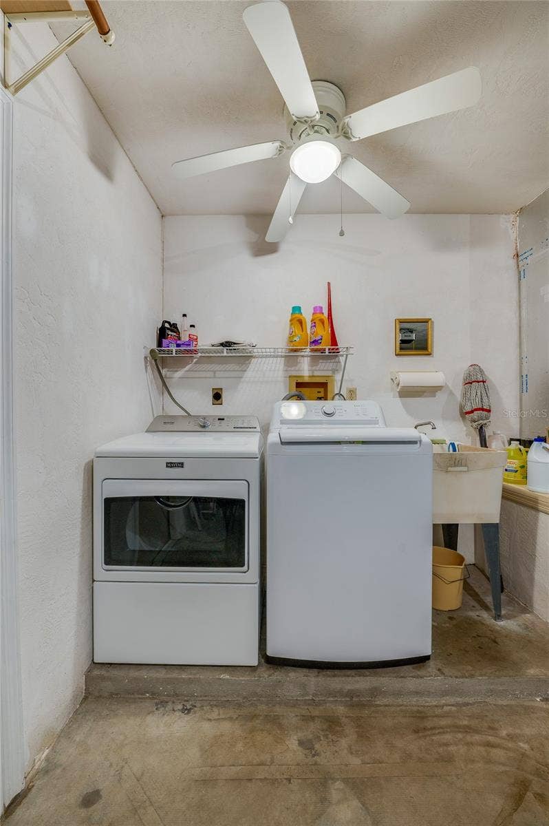 4669 SECRET RIVER TRAIL, Port Orange, FL 32129 Dedicated laundry area equipped with a side-by-side washer and dryer, utility sink, overhead wire storage rack, and a ceiling fan.
