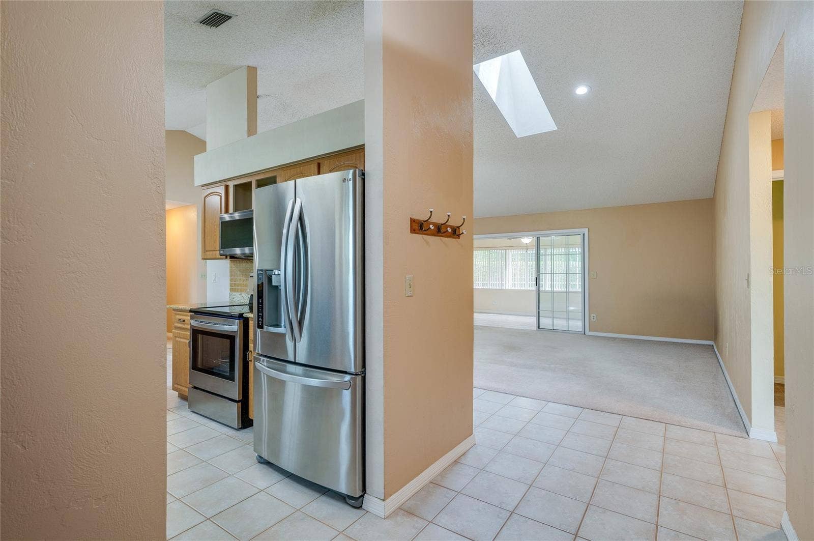 4669 SECRET RIVER TRAIL, Port Orange, FL 32129 Functional kitchen nook outfitted with stainless steel appliances, modern tiling, and recessed lighting. Skylights overhead enhance the bright, open interior feel.