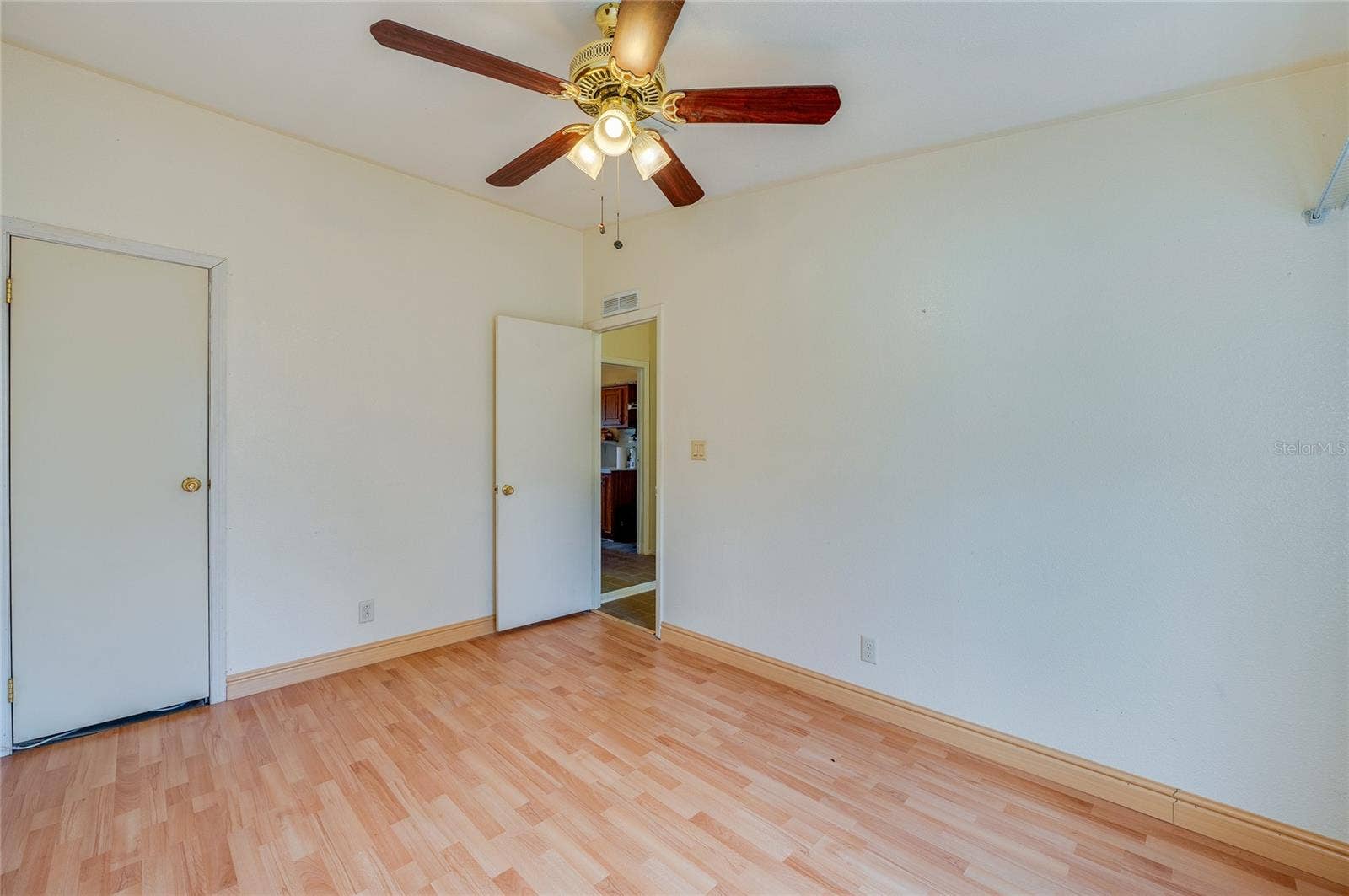 13 LAWRENCE COURT, Port Orange, FL 32127 Alternate view of the bedroom showcases its comfortable proportions, ceiling fan, and convenient storage.
