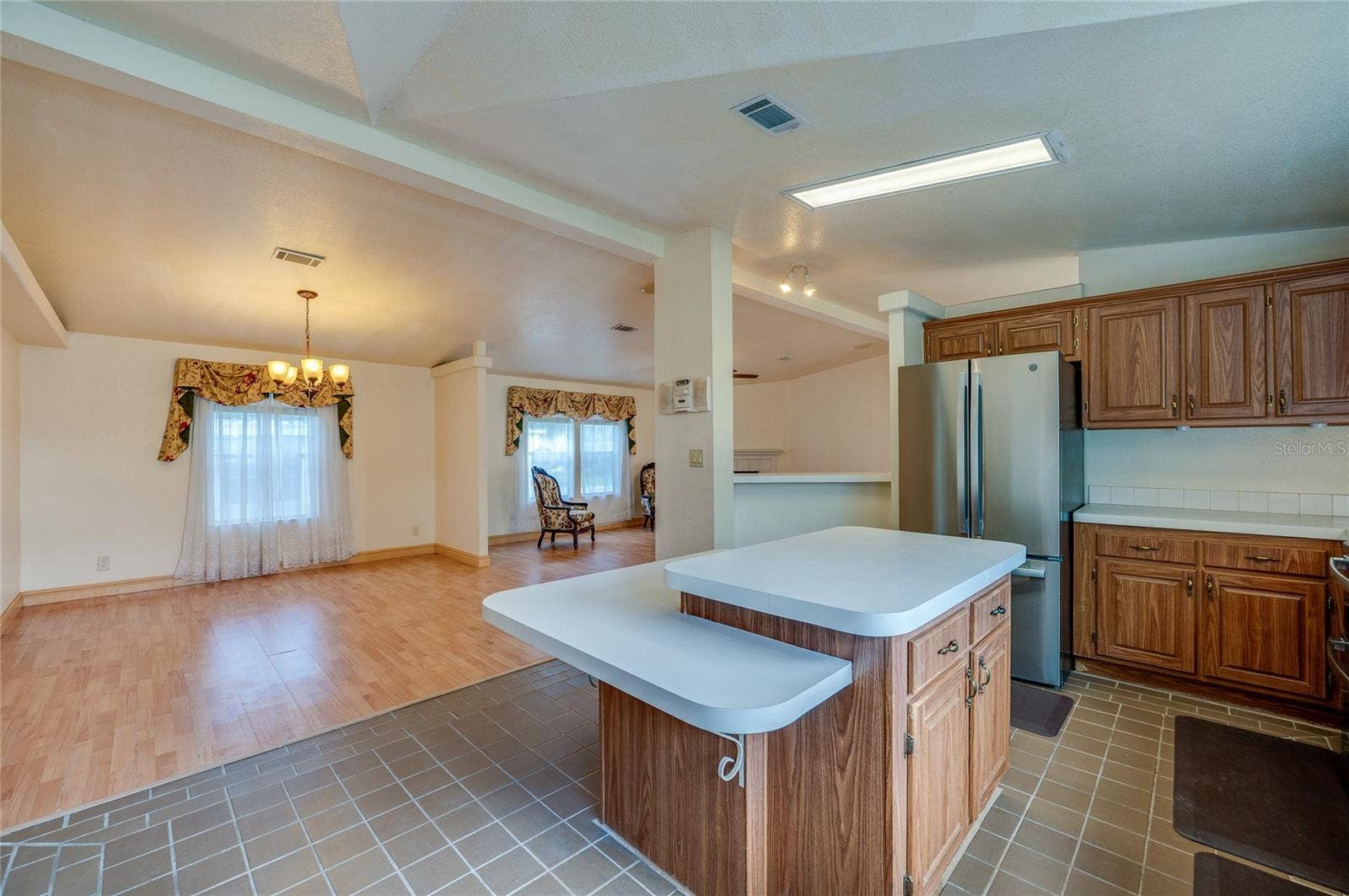 13 LAWRENCE COURT, Port Orange, FL 32127 View from the kitchen highlights the center island and the open connection to the adjacent dining and living areas.