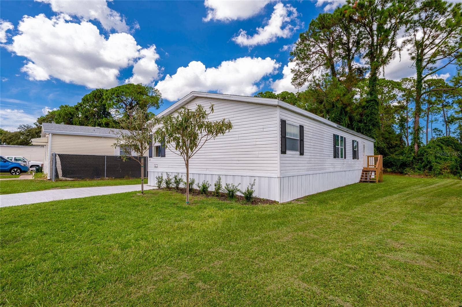 13 LAWRENCE COURT, Port Orange, FL 32127 Well-kept exterior with light siding, contrasting shutters, fresh landscaping, and a spacious lawn surrounding the home.