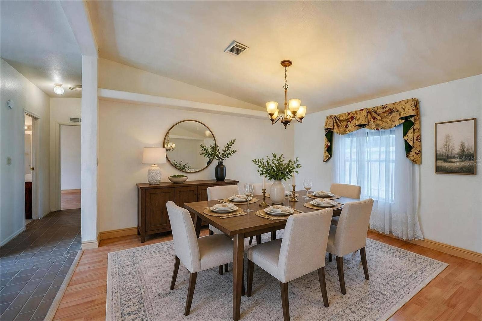 13 LAWRENCE COURT, Port Orange, FL 32127 Virtually Staged...Defined dining space features a chandelier and a large window for natural light, with an open connection to the surrounding living areas.