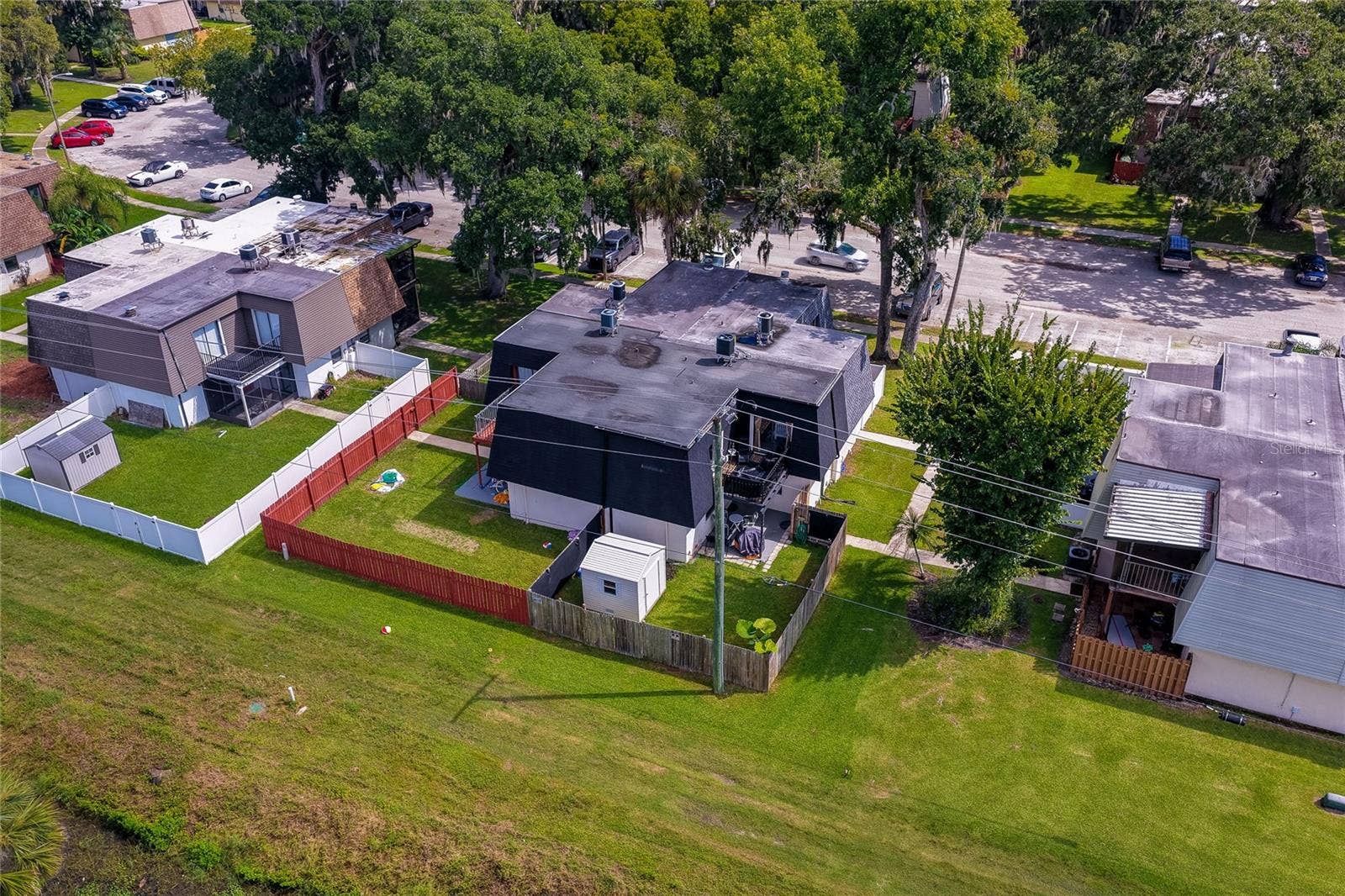 36 SPRINGWOOD SQUARE, Port Orange, FL 32129 Elevated aerial view of the residential unit emphasizing its private yard, roofline layout, and mature surrounding trees.