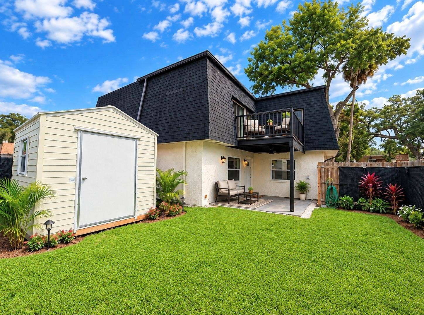 36 SPRINGWOOD SQUARE, Port Orange, FL 32129 Generously sized yard featuring a detached storage shed, privacy fencing, and a concrete patio area.