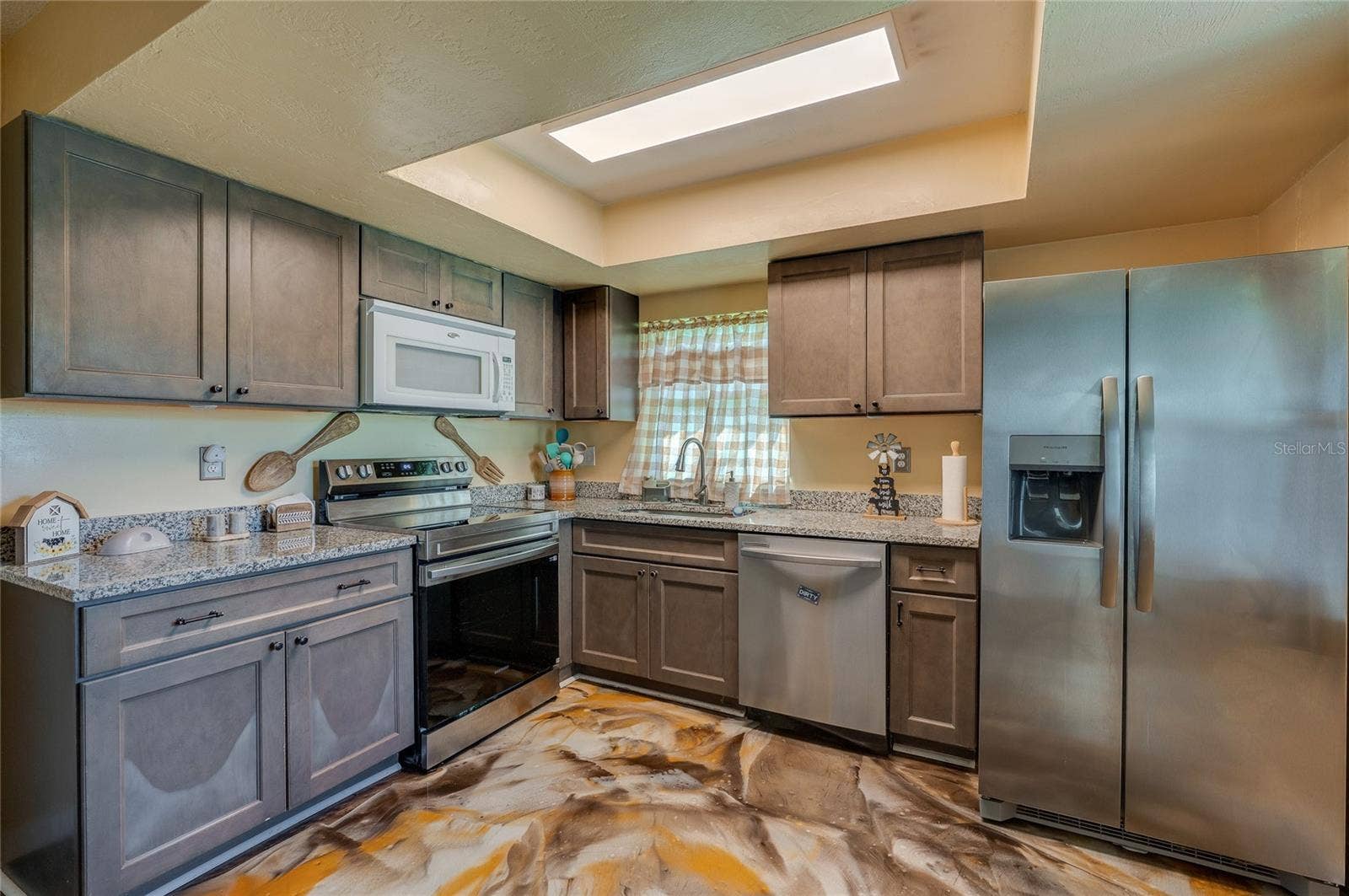 36 SPRINGWOOD SQUARE, Port Orange, FL 32129 Upgraded kitchen area highlighting a full suite of stainless steel appliances, recessed ceiling light box, and custom epoxy flooring.