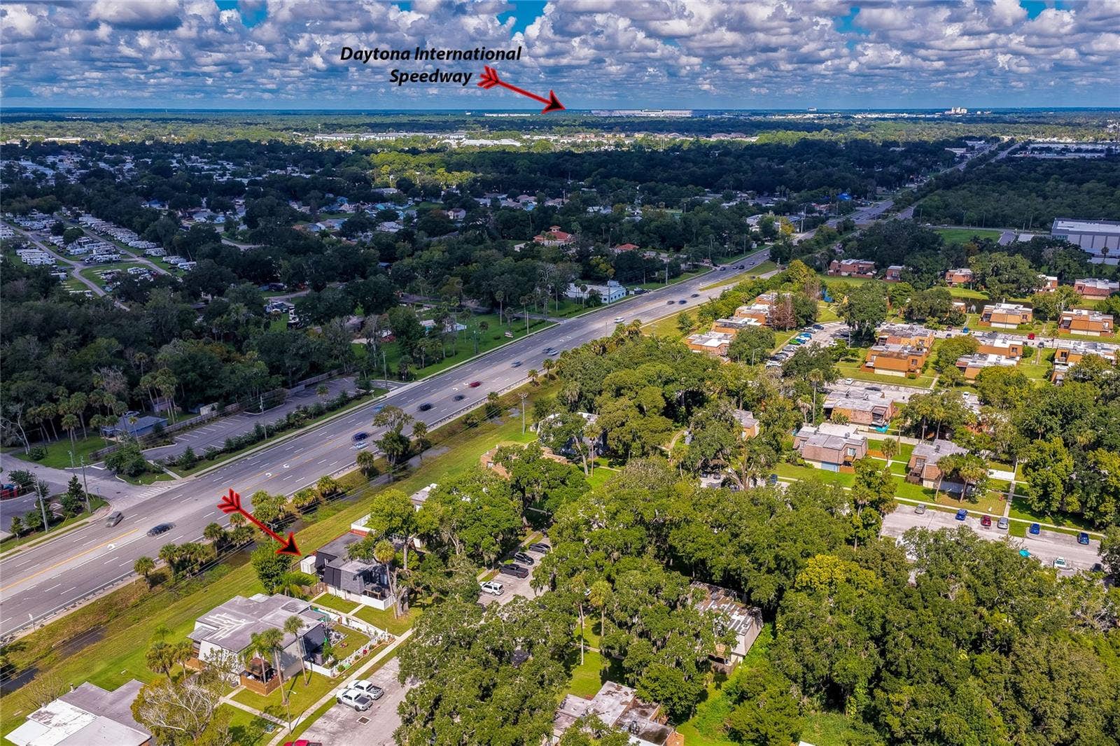 36 SPRINGWOOD SQUARE, Port Orange, FL 32129 Panoramic aerial perspective highlighting the residence's location relative to surrounding neighborhoods, major roadways, and nearby landmarks like the Daytona International Speedway.