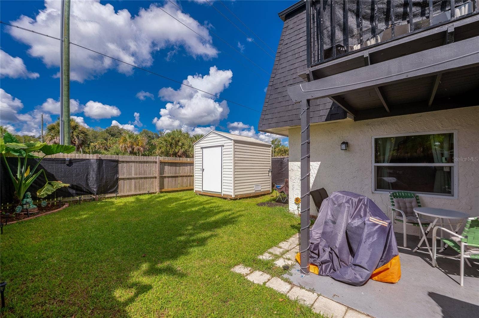 36 SPRINGWOOD SQUARE, Port Orange, FL 32129 Generously sized back yard featuring a detached storage shed, privacy fencing, and a concrete patio area.