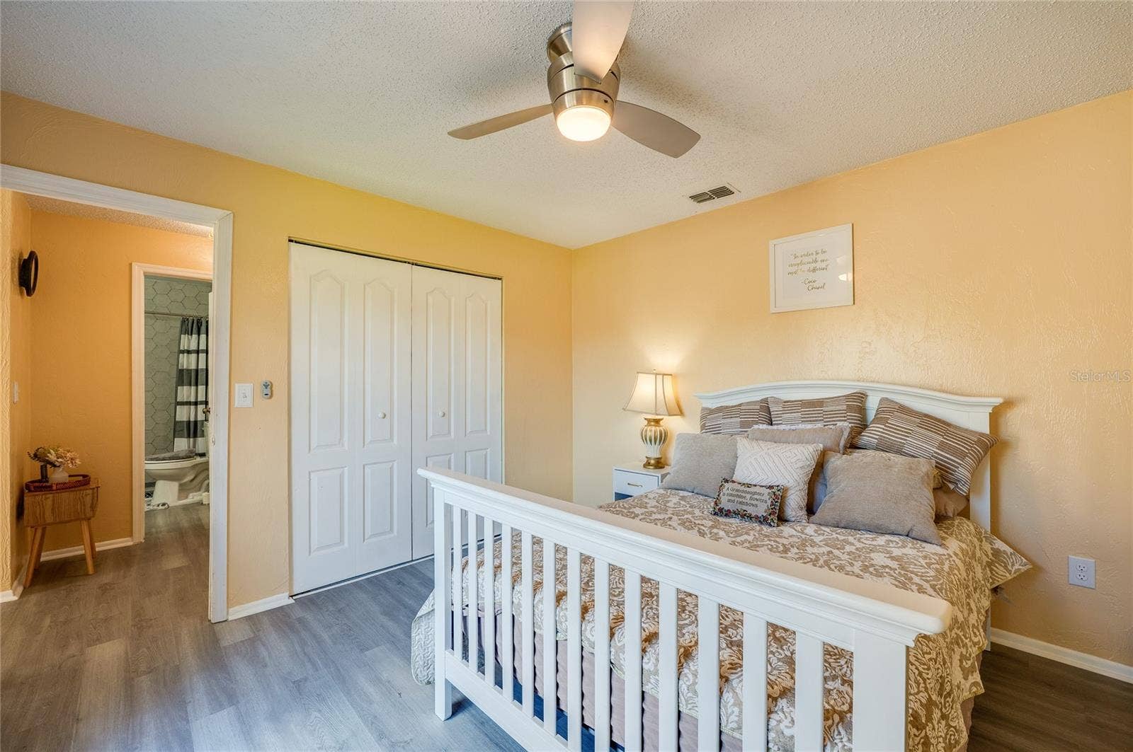 36 SPRINGWOOD SQUARE, Port Orange, FL 32129 Light-filled room featuring LVP flooring, modern ceiling fan, and sliding closet doors.