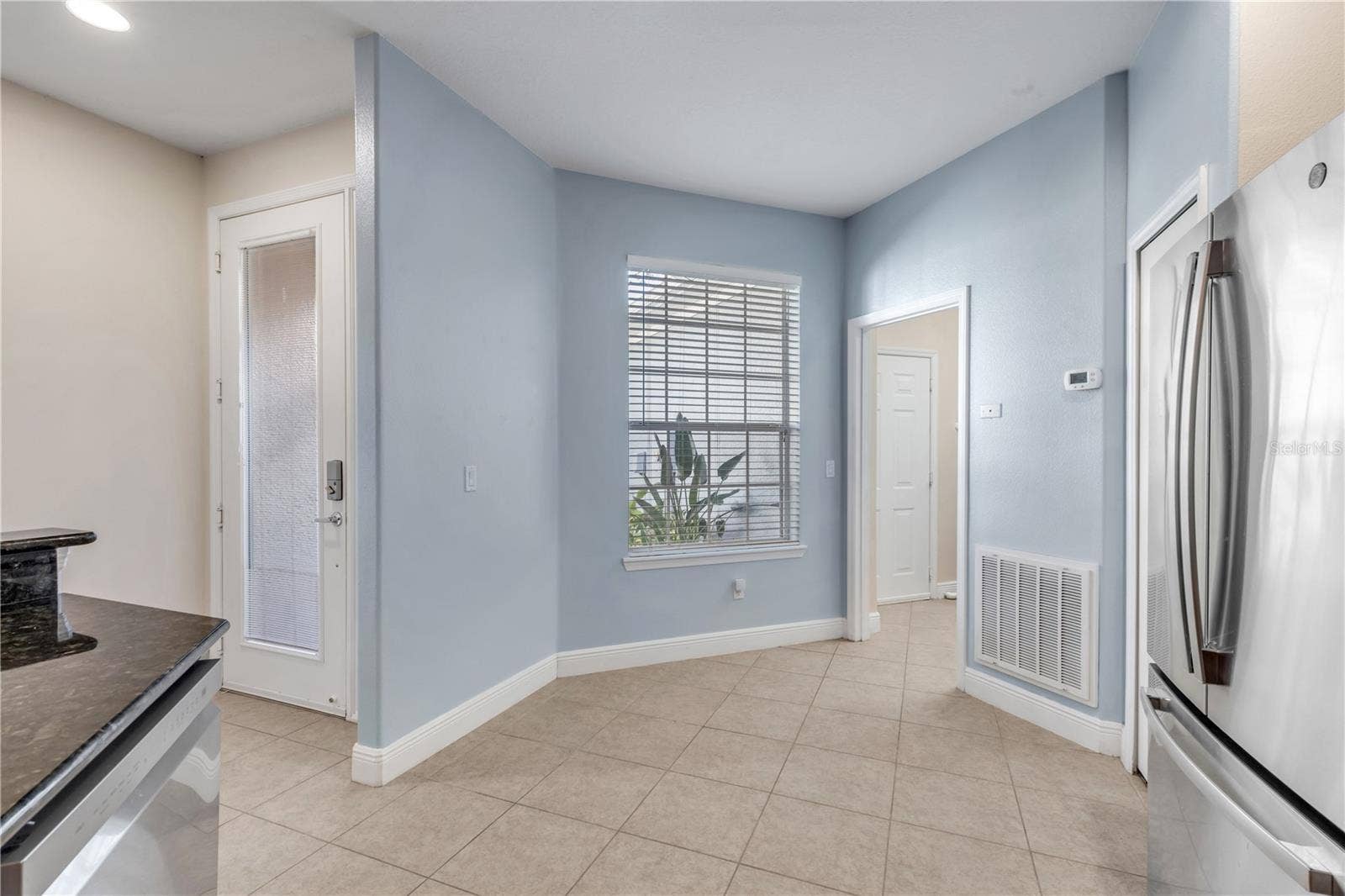front door entry way leading into the kitchen, further into the laundry and garage