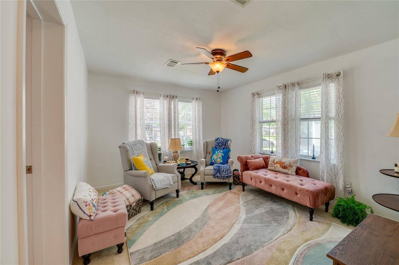 60 GOLDEN GATE CIRCLE, Port Orange, FL 32129 Spacious room with smooth carpeting, double-hung windows, and a ceiling fan fixture. Neutral walls provide an open, airy feel throughout.
