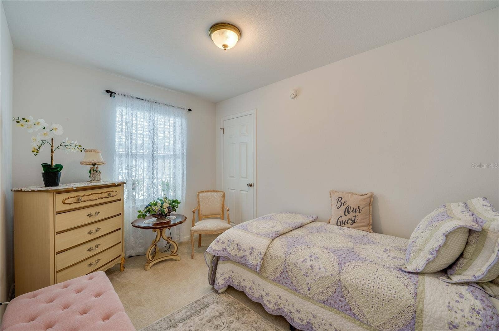 60 GOLDEN GATE CIRCLE, Port Orange, FL 32129 Cozy bedroom featuring neutral walls, low-maintenance carpet, a flush-mount light fixture, and a standard closet door. A centered window brings in soft natural light.