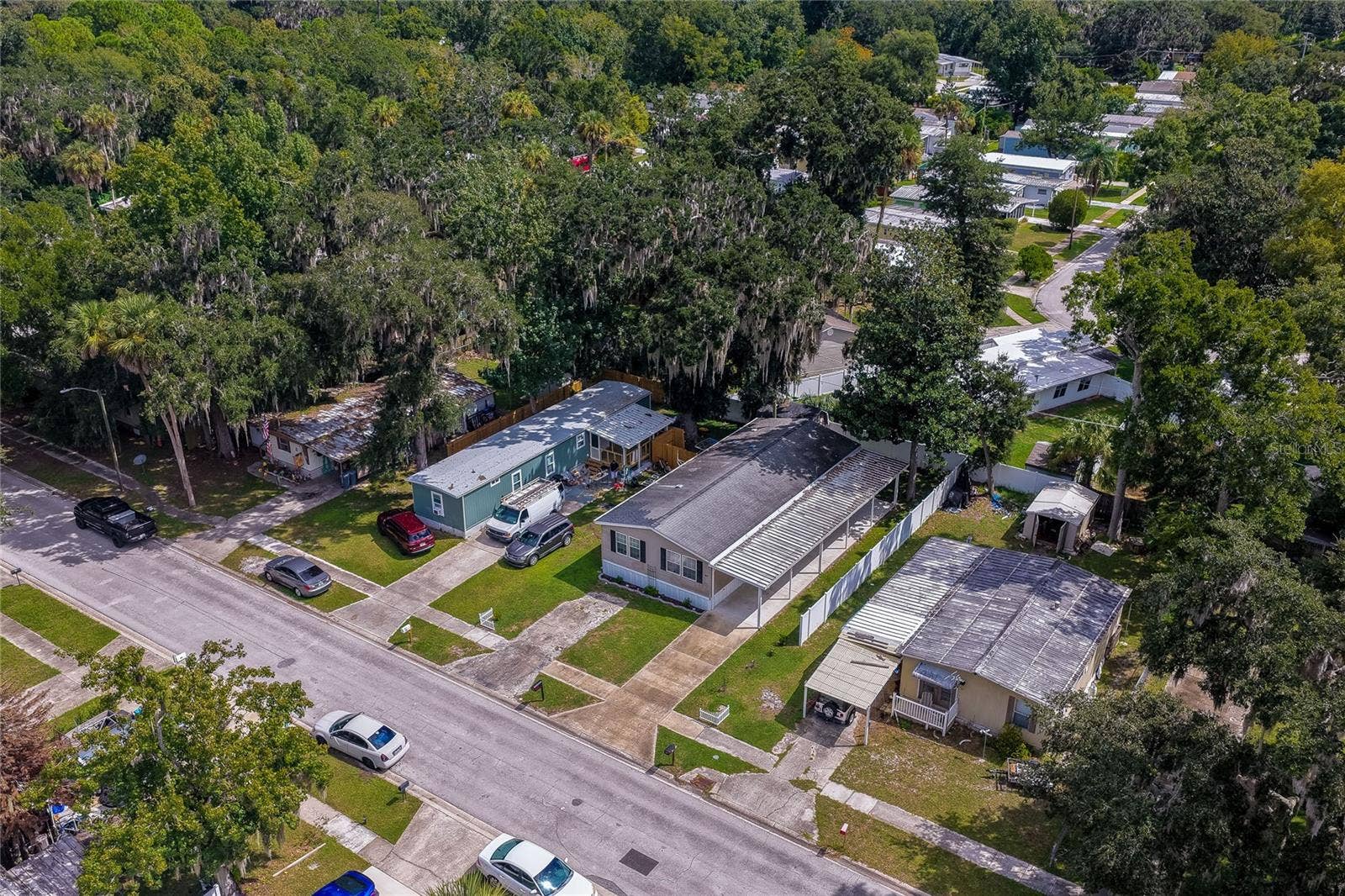 60 GOLDEN GATE CIRCLE, Port Orange, FL 32129 Elevated neighborhood view showing the home's layout, covered carport, detached shed, and surrounding residential street.