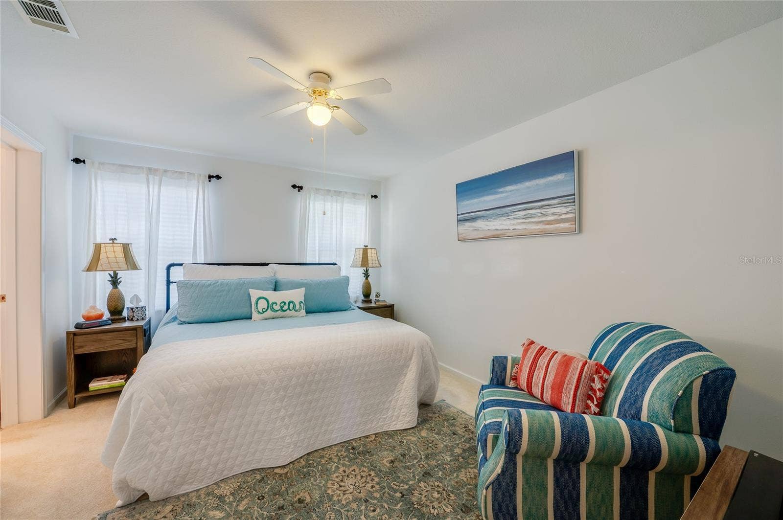 60 GOLDEN GATE CIRCLE, Port Orange, FL 32129 Comfortable bedroom suite featuring light neutral paint, carpeted flooring, two bright windows, and a central ceiling fan.