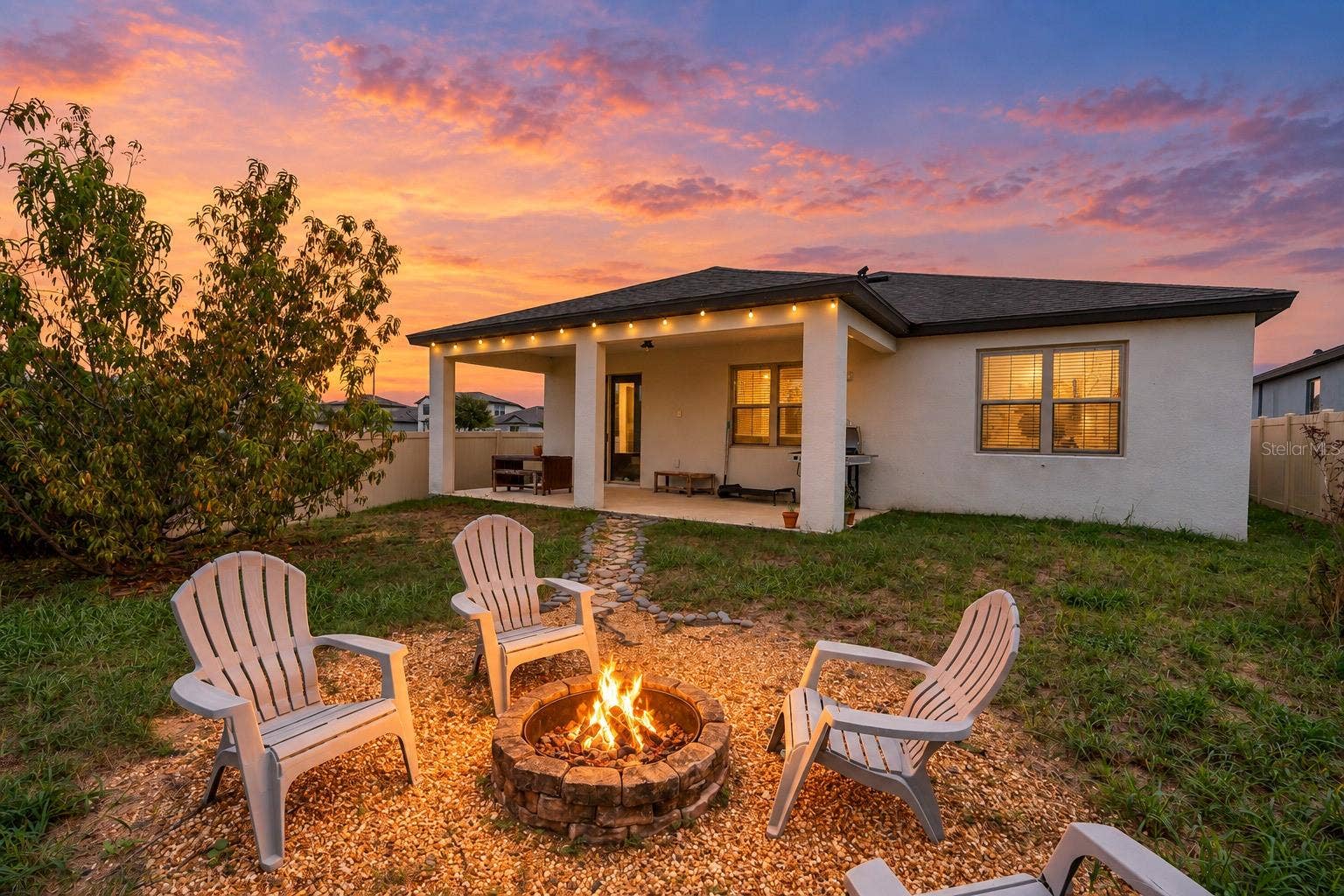 twilight of rear patio, yard and fireplace