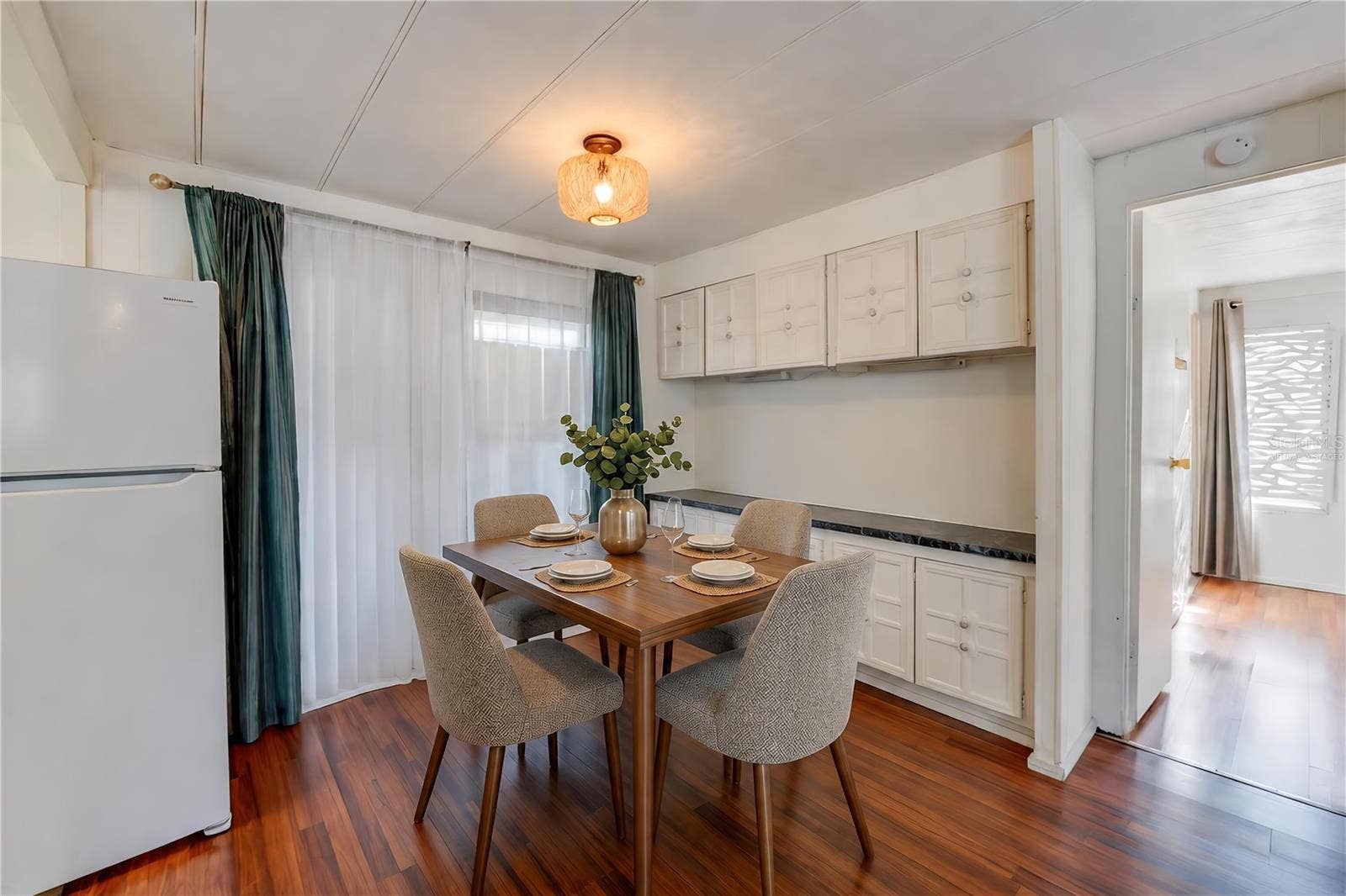 Virtually Staged - Dedicated dining space features extensive built-in cabinetry and countertop space, with a large window bringing natural light into the room.