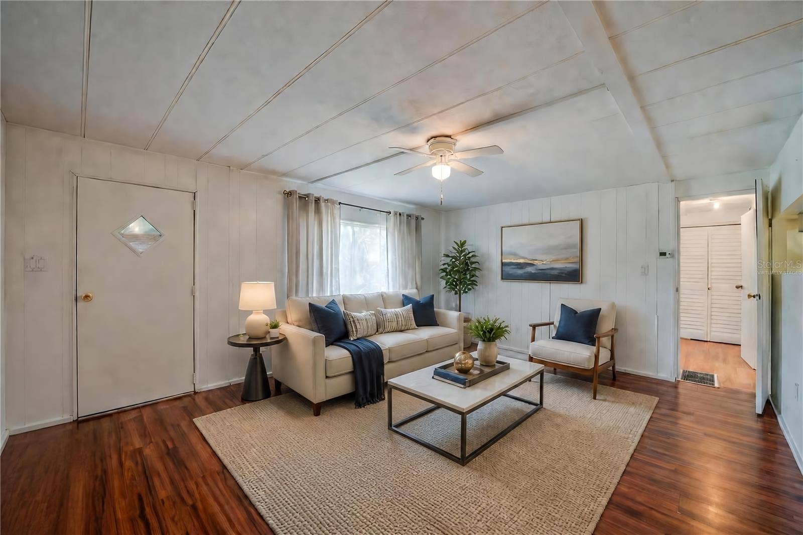Virtually Staged - Expansive living room offers plenty of flexibility for multiple furniture arrangements, along with a ceiling fan and a large window overlooking the exterior.