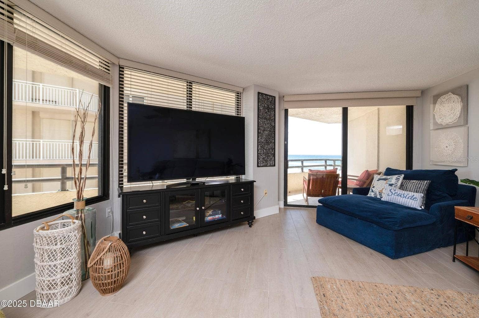 This bright and inviting living room features expansive windows and sliding glass doors opening to the private balcony, where beautiful Atlantic Ocean views await.