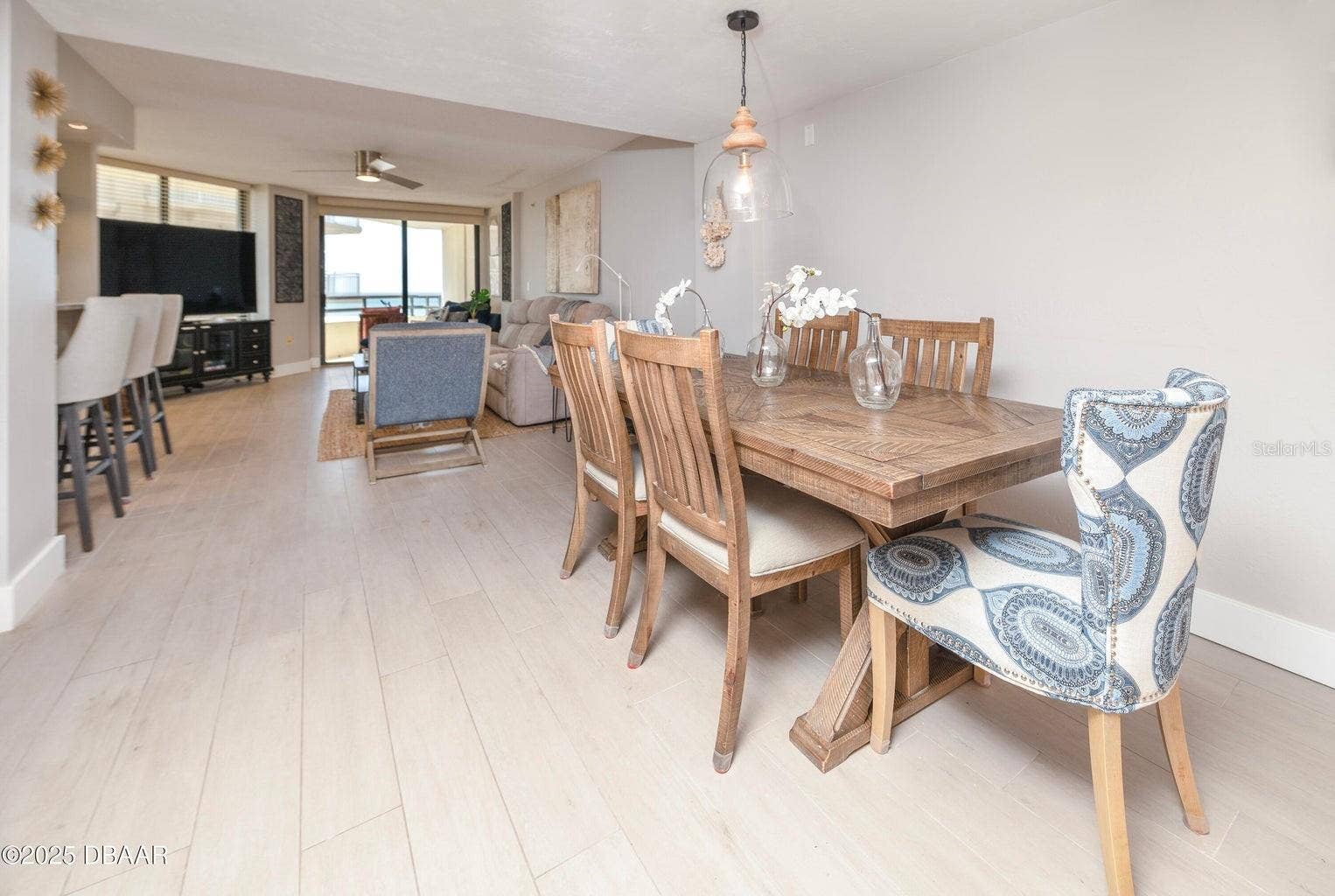 Enjoy an open, connected floor plan that brings together the dining room, kitchen, and living area. Neutral finishes and a direct view toward the oceanfront balcony enhance the relaxed coastal atmosphere.