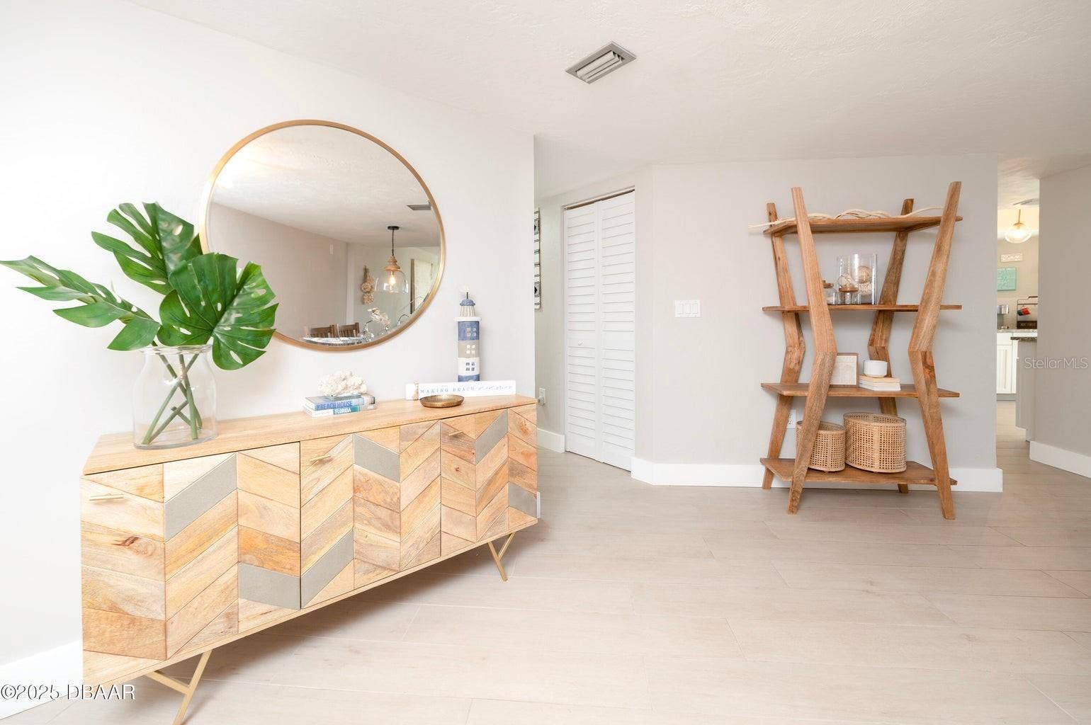 This bright, coastal-inspired entry features neutral tones, creating an inviting introduction to the residence.