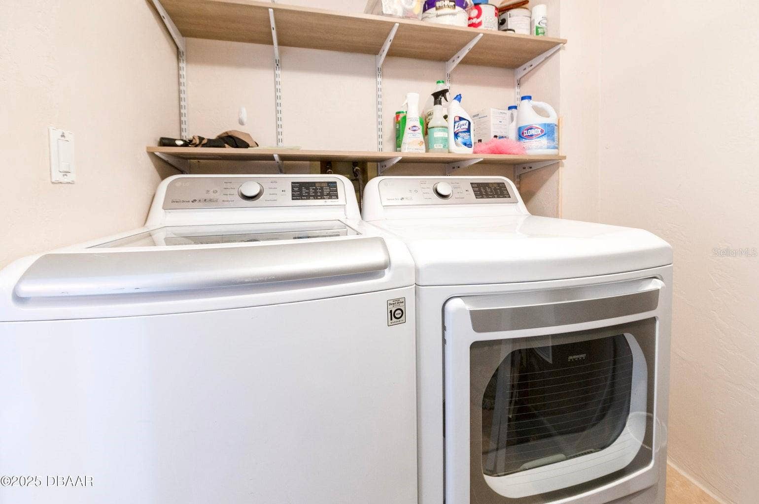 Enjoy the convenience of a dedicated laundry area featuring a full-size washer and dryer, along with overhead shelving for organized storage of laundry essentials.