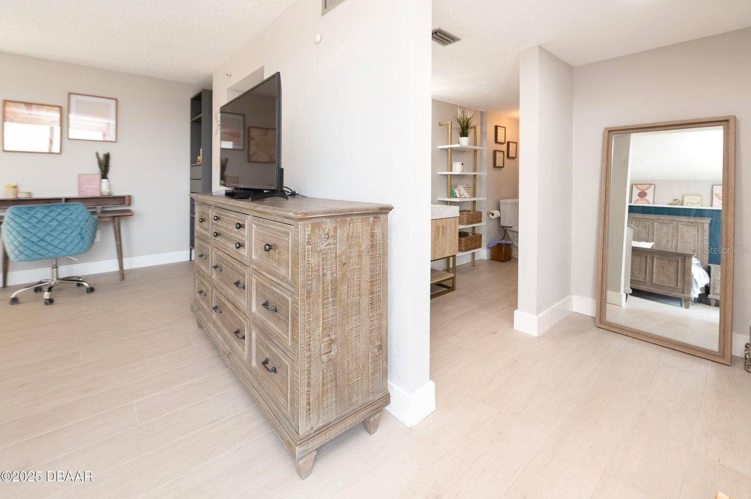 The primary suite offers a spacious dressing area with room for additional furnishings and convenient access to the adjoining bathroom.