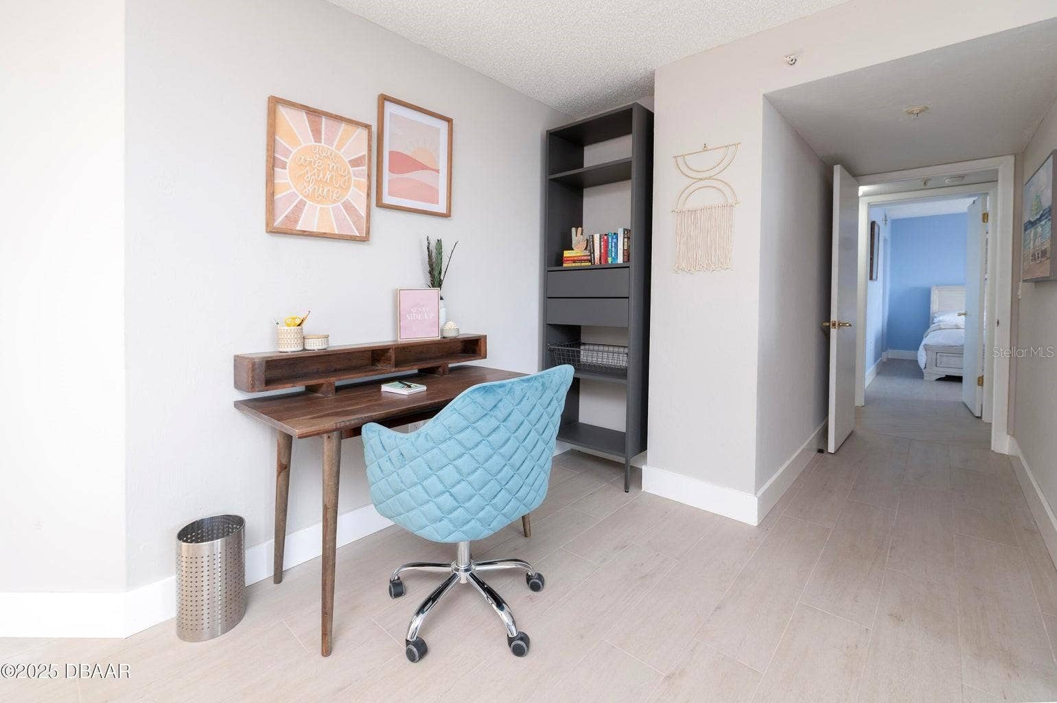 A convenient workspace within the primary suite offers room for a desk and shelving, providing a functional area for remote work, reading, or organizing daily essentials.