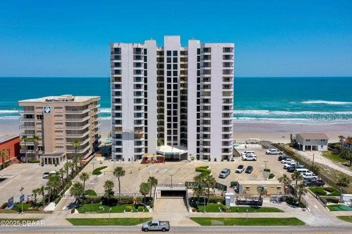 The building's clean faade and gated entrance welcome residents with manicured landscaping, ample parking, and ocean views from every level.