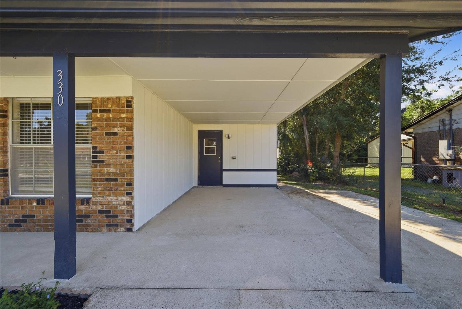 Carport with door to interior utility room.