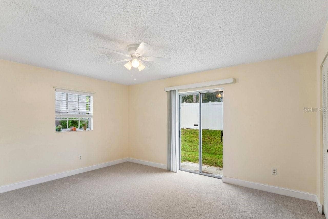The bedroom has a slider, window, ceiling fan, access to the bathroom and walk in closet, and brand NEW carpeting.