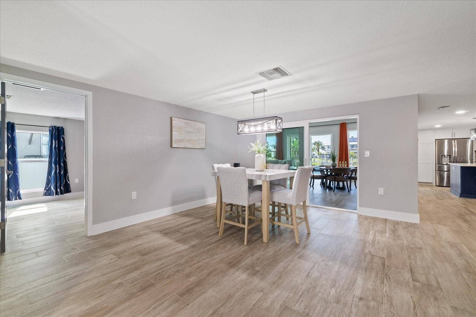 5001 MARLIN DRIVE, New Port Richey, FL 34652 View from entry of primary bedroom entry and family room sliders past dining table