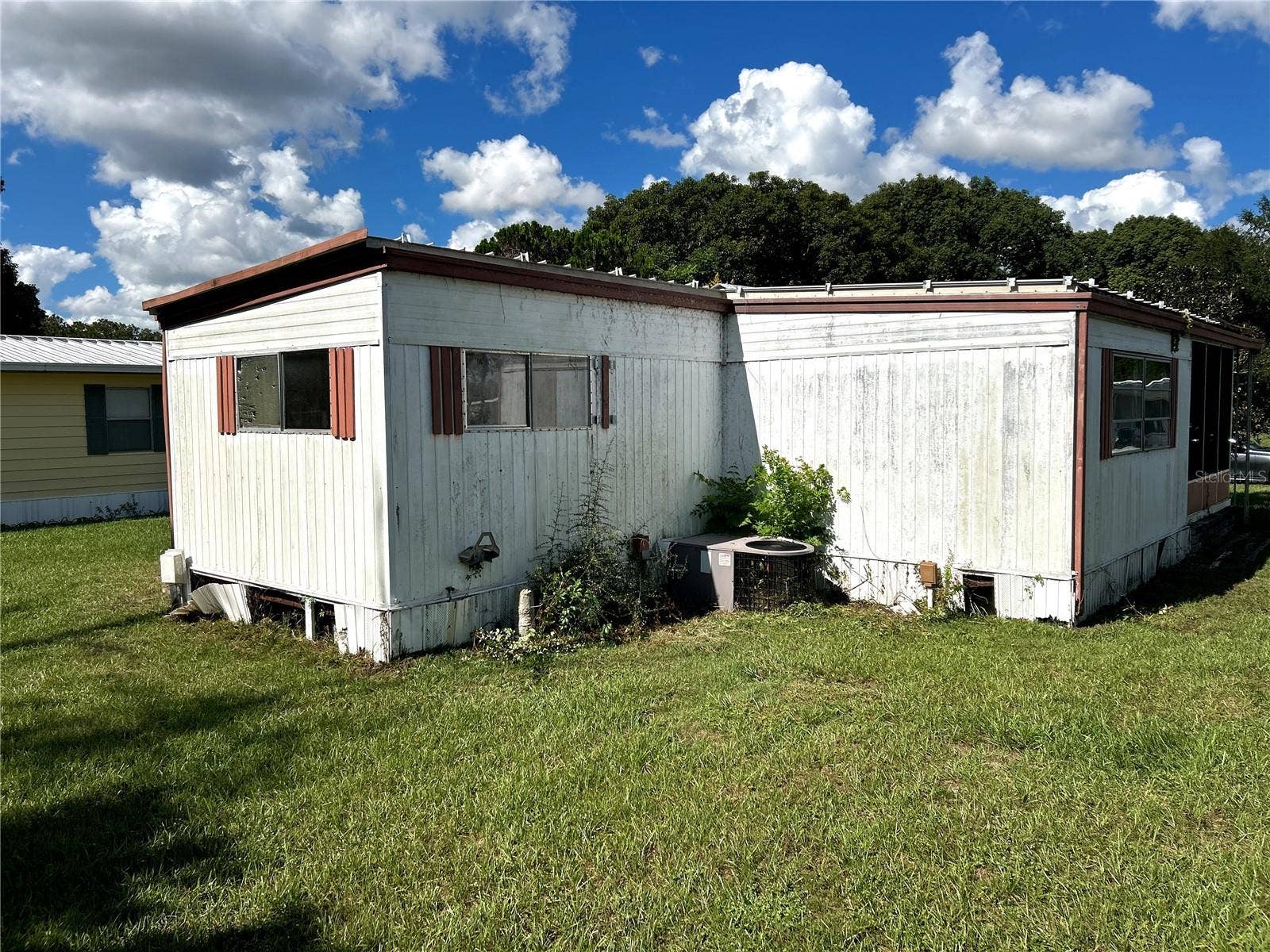 14506 DEHAVEN AVENUE, Brooksville, FL 34613 other view of back of home facing primary bedroom, AC unit and living room.