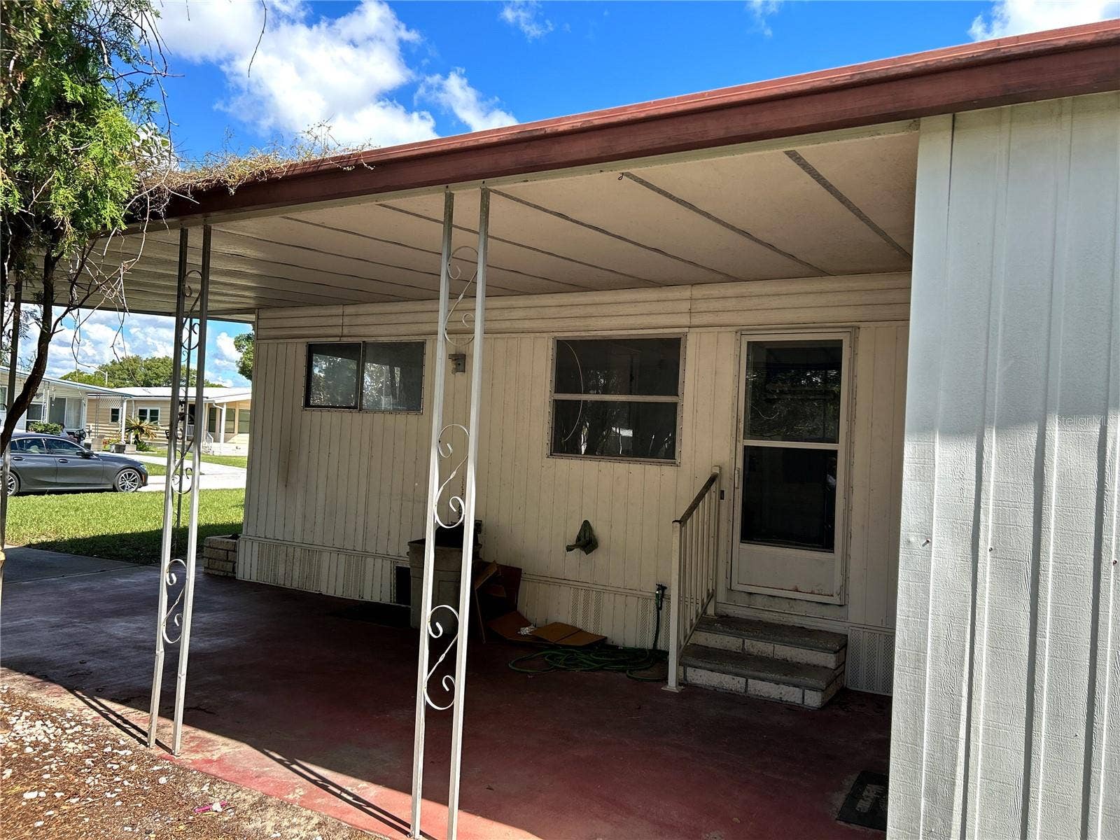 14506 DEHAVEN AVENUE, Brooksville, FL 34613 side view looking into carport and utility room/ laundry room with door to kitchen.
