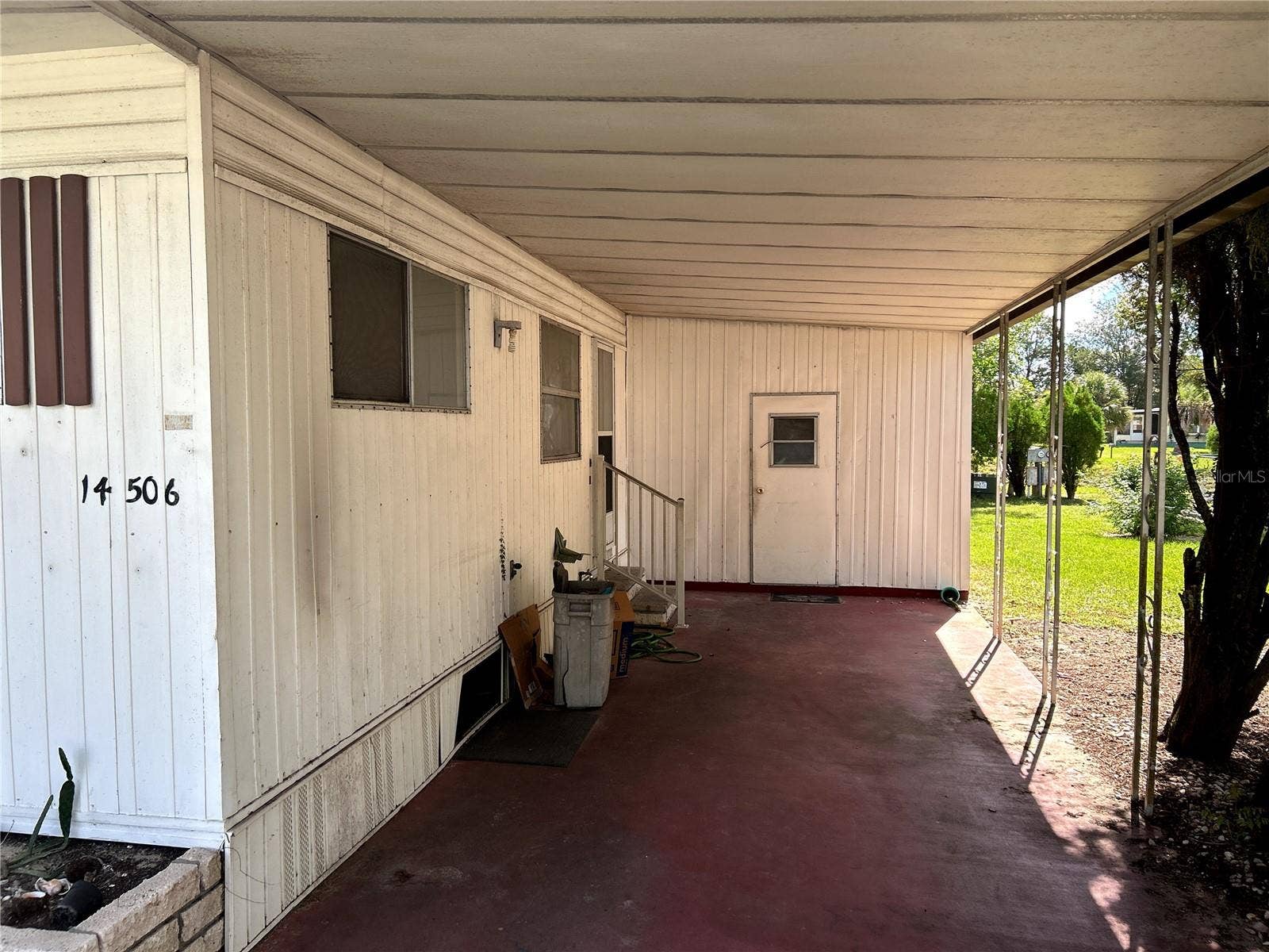 14506 DEHAVEN AVENUE, Brooksville, FL 34613 covered carport, utility room/ laundry room and entrance to kitchen.