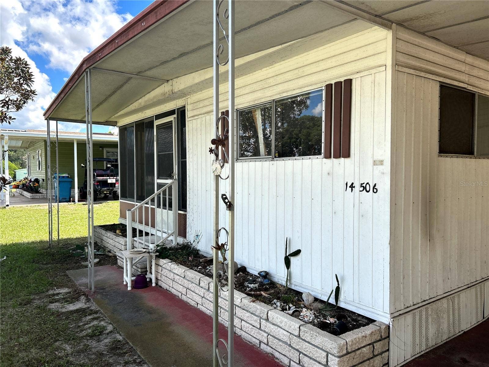 14506 DEHAVEN AVENUE, Brooksville, FL 34613 Front view of sidewalk and covered porch area to covered carport.