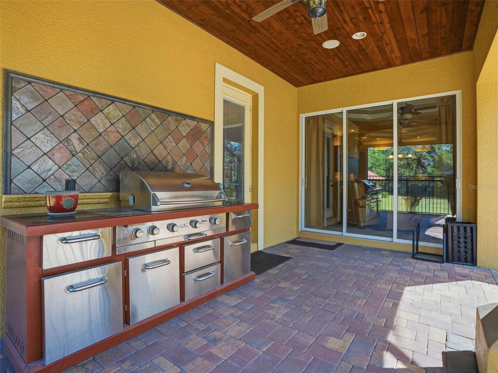 9313 HERNANDO RIDGE ROAD, Weeki Wachee, FL 34613 Outdoor kitchen with propane grill and seating area overlooking the pool. Easy access to the kitchen.