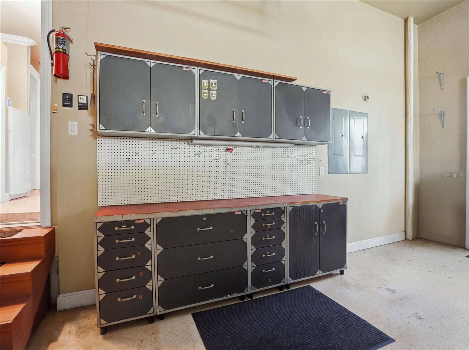 9313 HERNANDO RIDGE ROAD, Weeki Wachee, FL 34613 Workshop table and cabinets in the 3-car garage.