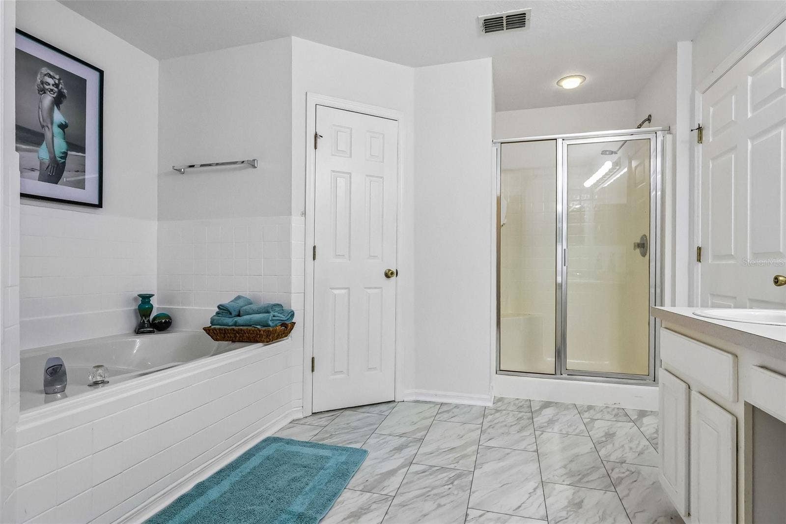 Master bath with water closet, stand up shower, soaking tub, and two walk-in closets.