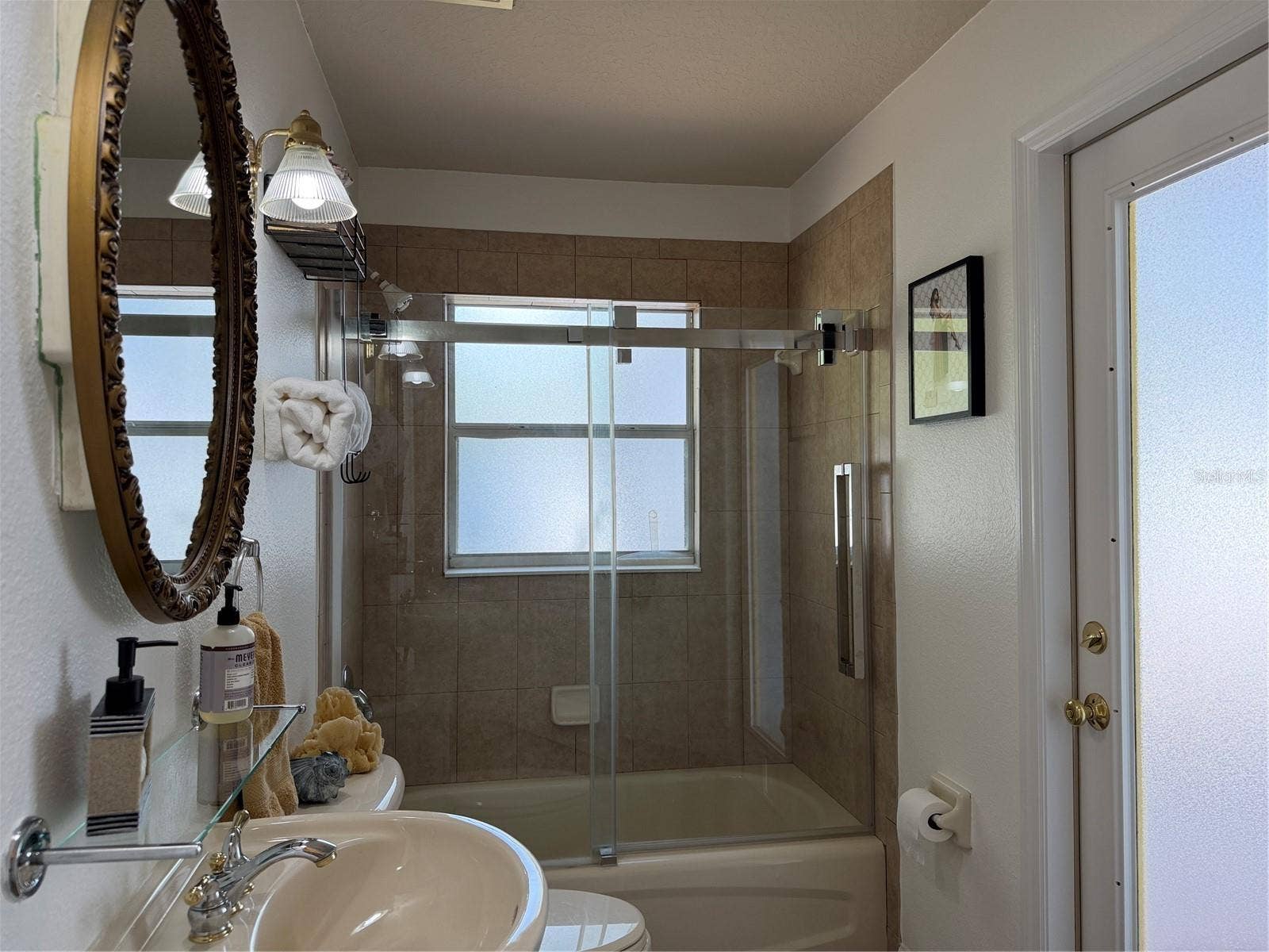 2nd bathroom has tub with shower and a quality sliding shower door
