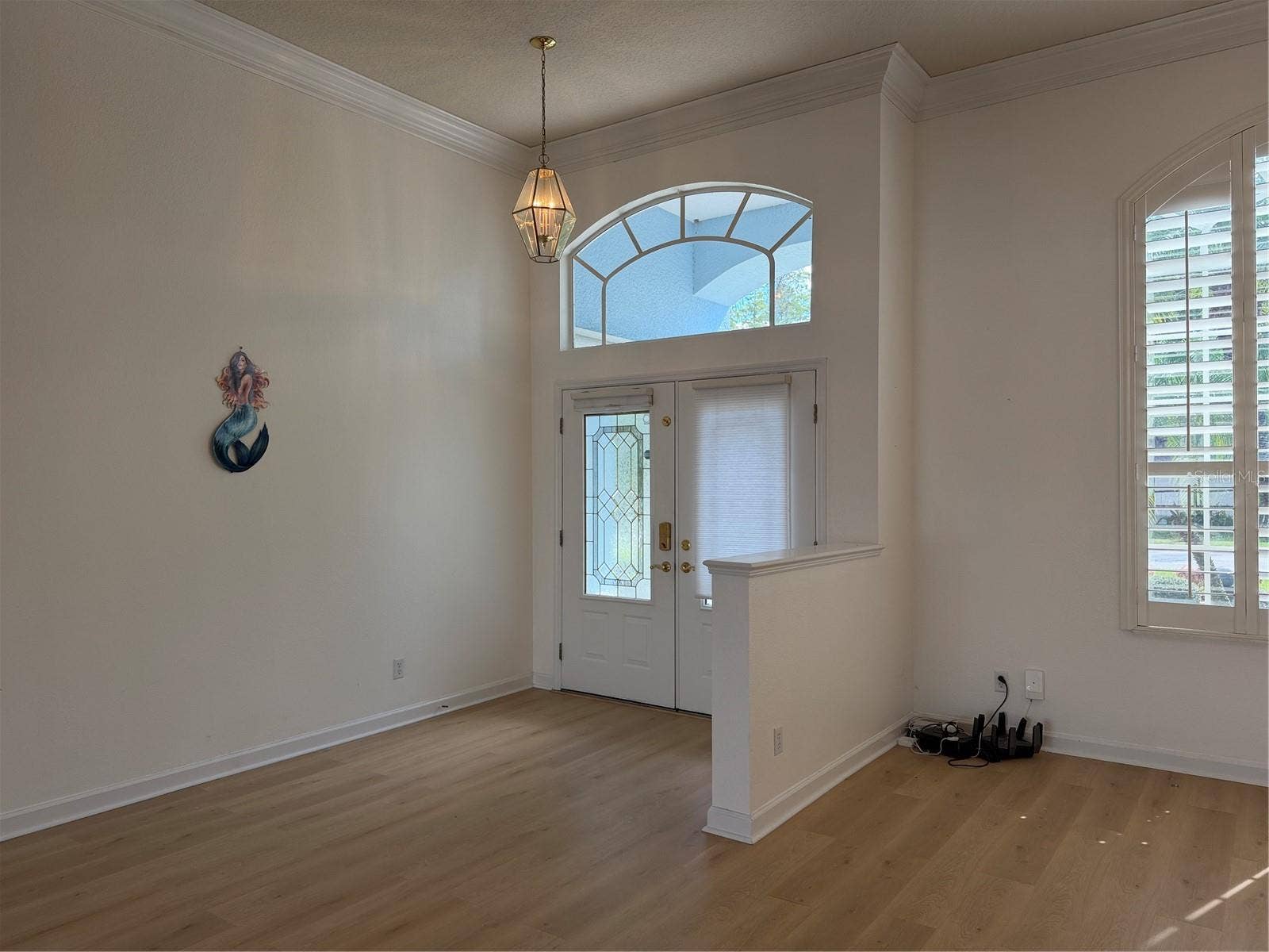 Front entrance of home has transom window above doors allowing more natural light