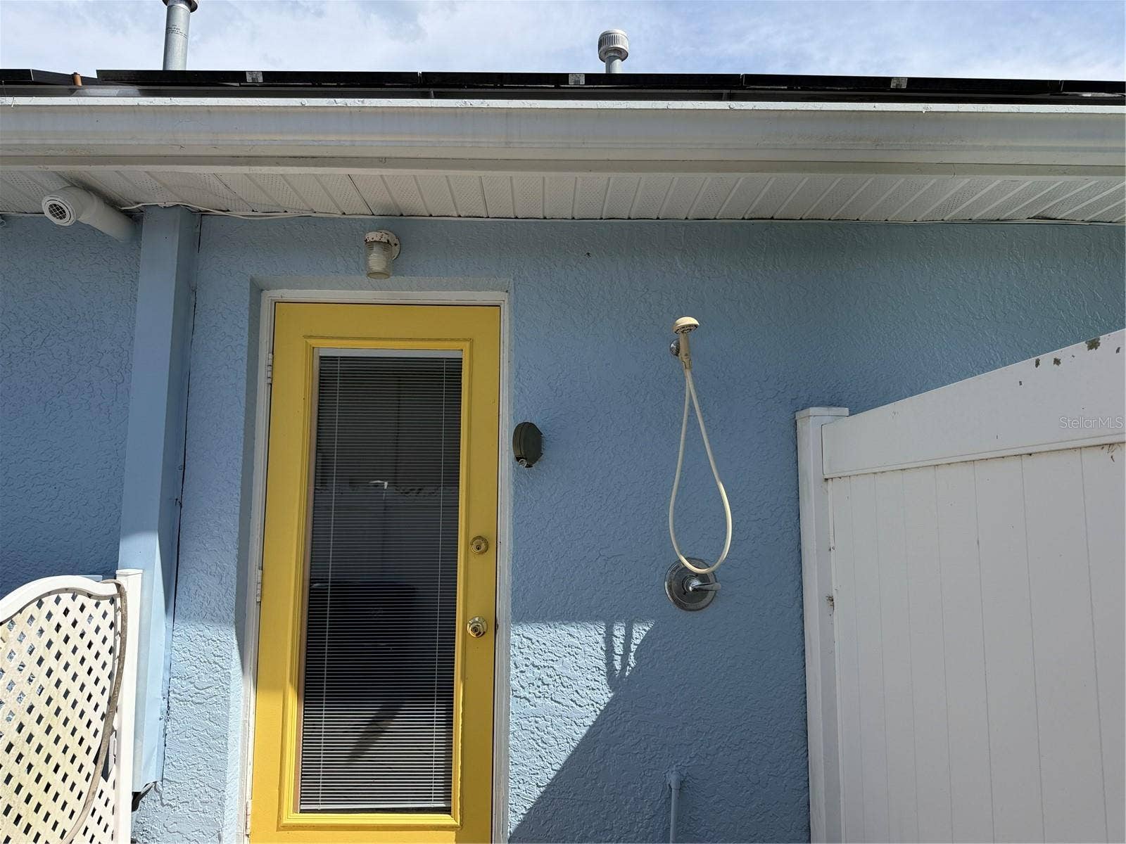 Outdoor shower to the right of the door that leads to bonus room. Tankless water heater in house