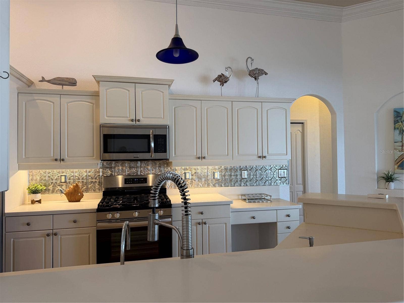 decorative metal tiles adorn the wall under cabinets