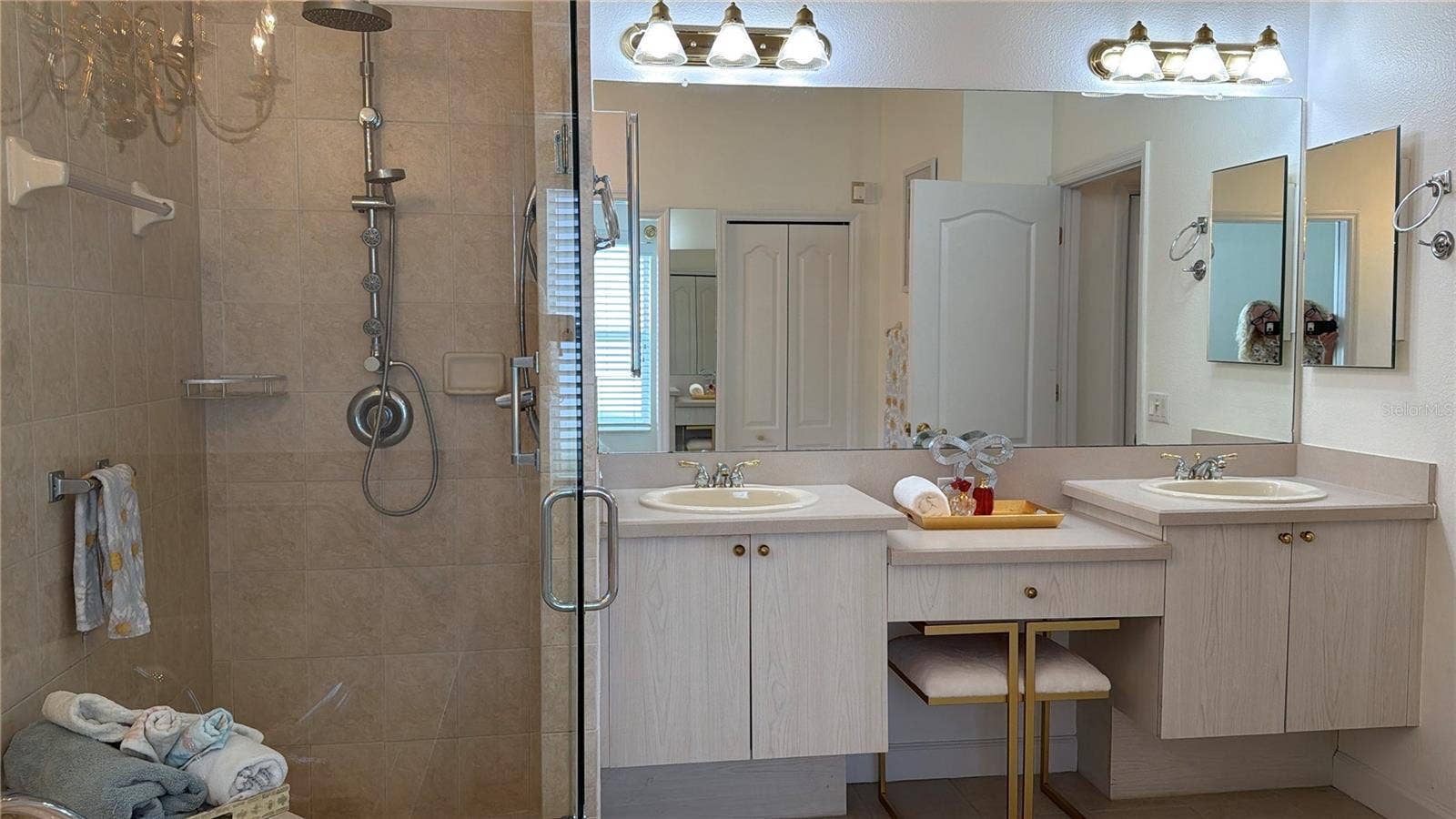 Shower has built in seat, and multiple shower heads and jets