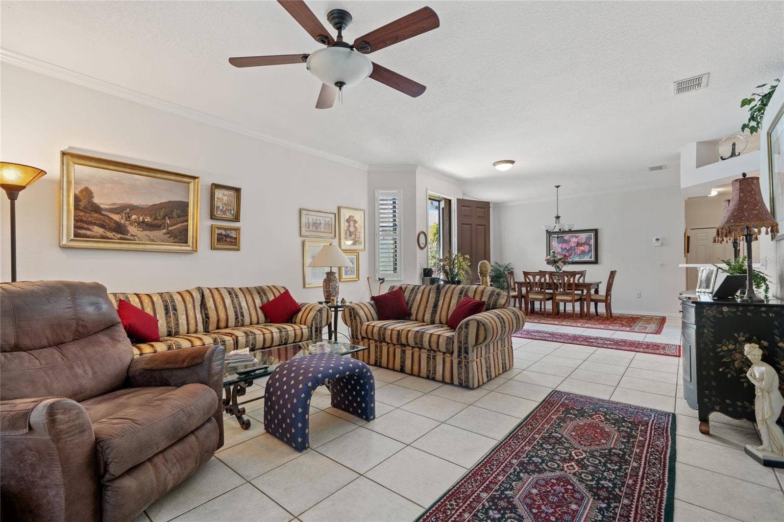 8112 AMBERSWEET PLACE, Land O Lakes, FL 34637 LIVING ROOM WITH VIEW TO DINING ROOM AND FRONT DOOR.